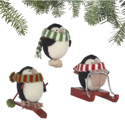 A set of three penguin ornaments made of soft alpaca blend wool by rural Peruvian women is shown. Crate & Barrel collaborated on the collection with a fair trade group that helps the women earn money to support and sustain their families.