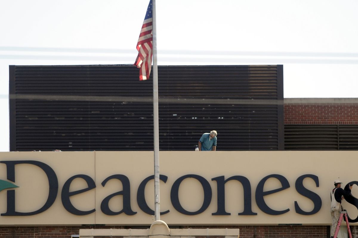 Workmen hang letters for a new sign atop Deaconess Medical Center in 2009. (File)