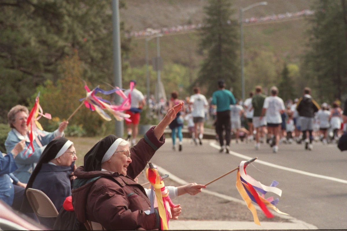 Sisters Antonia and Gellanda wave to runners as they approach Doomsday Hill during Bloomsday 2002. (Roger Ames photo. / SR)