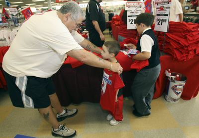 Associated Press Jerry Scena checks a Phils’ T-shirt size for his grandson Thursday. (Associated Press / The Spokesman-Review)