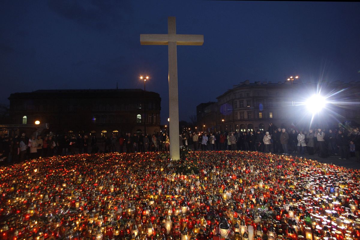 A  cross and candles are seen on Pilsudski Square in central Warsaw on Sunday, as people gather to pay their respects to those killed aboard the Polish presidential plane that crashed Saturday in Smolensk, Russia. Associated Press photos (Associated Press photos)