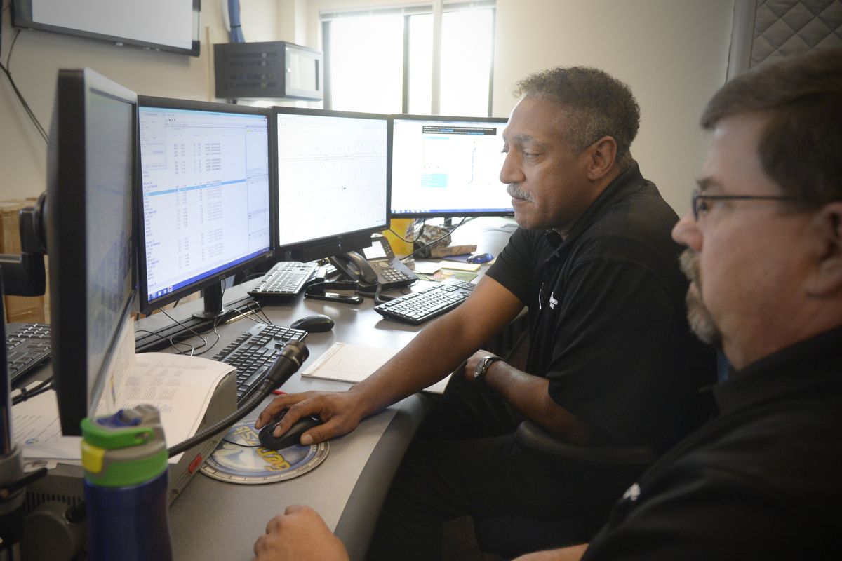 In the Spokane Transit Authority dispatch center Aug. 31, supervisor Sam Hairston, center, and supervisor-in-training Mark Fischer observe the entire STA bus system using real-time information from each vehicle. (Jesse Tinsley)