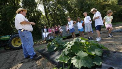 
Bob Jones, left, shows children some of the crops at the The Culinary Vegetable Institute in Milan, Ohio, Wednesday, Aug. 16. 
 (Associated Press / The Spokesman-Review)