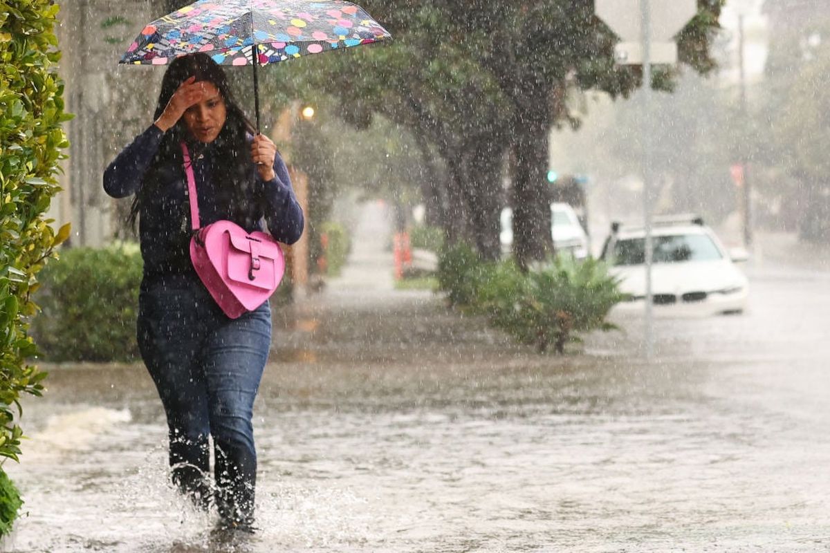 A person walks along a flooded street as a powerful long-duration atmospheric river storm, the second in less than a week, impacts California on Feb. 4 in Santa Barbara, Calif. The storm is delivering potential for widespread flooding, landslides and power outages while dropping heavy rain and snow across the region.  (Getty Images)