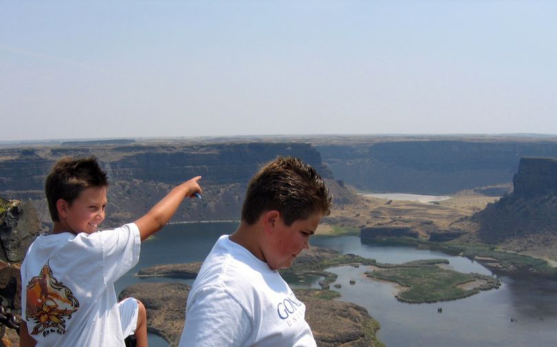 Adam Deutsch, left, and Max Bergam look out over Dry Falls, which gushed with water between 12,000 and 18,000 years ago when catastrophic floods poured through the Pacific Northwest. Dry Falls is located in Sun Lakes-Dry Falls State Park, 25 miles south of Coulee Dam on state Highway 17, just off U.S. Highway 2.rebeccan@spokesman.com (Rebecca Nappi / The Spokesman-Review)