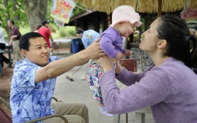 
Sam Song, Spokane Parks and Recreation Department food and beverage supervisor, hands Elaine Korn,  6 months, back to her mother Amy Shook during opening day at the Park Bench Café on Saturday.  Song was visiting with patrons during the noon hour. 
 (Dan Pelle / The Spokesman-Review)