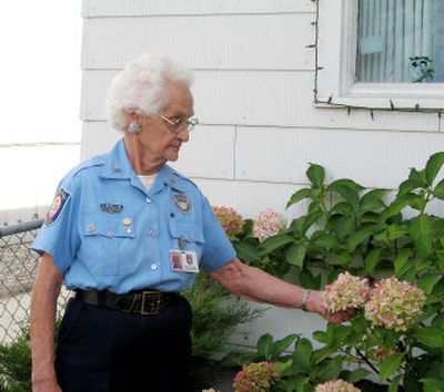 
Ruth Berglund, 95, examines a flower in the yard of her South Hill home. Berglund averages about 50 hours a week as a volunteer for the Spokane Police Department. She works in the information booth at either the County Courthouse or the STA Plaza. 
 (Valerie Putnam photo / The Spokesman-Review)