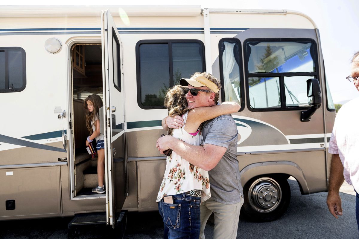 Woody Faircloth hugs Sheri Roen as her family donates their motorhome to EmergencyRV.org on Sunday, Sept. 5, 2021, in Sierra County, Calif. Accompanied by daughter Luna, left, Faircloth delivered it to a Dixie Fire victim later that day,  (Noah Berger)