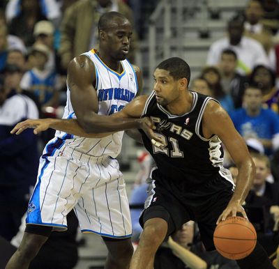Spurs’ Tim Duncan (21) is guarded by Hornets’ Emeka Okafor. (Associated Press)