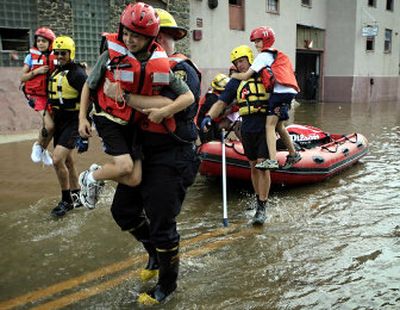 
Firefighters rescue children trapped by floodwaters in the Arthur Ashe Youth Tennis Center in the Manayunk section of Philadelphia on Wednesday. 
 (Associated Press / The Spokesman-Review)