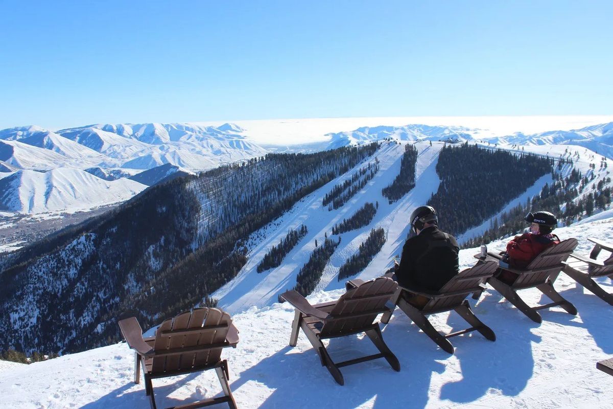 Skiers relax on deck chairs with expansive views of the Pioneer Mountains from atop Bald Mountain, where the bulk of Sun Valley ski resort is situated. (Gregory Scruggs/Seattle Times)