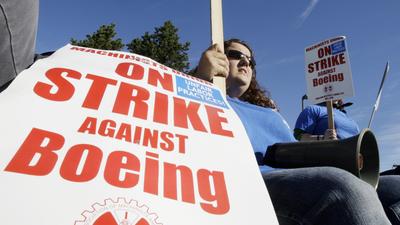 Jennifer Oakman, who normally works assembling wings for Boeing 737 airplanes, staffs a picket line at Boeing Co.’s Renton, Wash. assembly plant Monday. Boeing workers in Washington, Oregon and Kansas began the strike on Saturday.  (Associated Press / The Spokesman-Review)