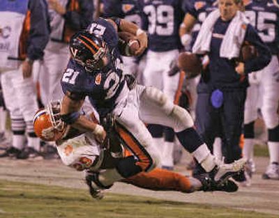 
Alvin Pearman, a second-half replacement at running back for Virginia, fights Clemson's Travis Pugh for extra yardage. 
 (Associated Press / The Spokesman-Review)