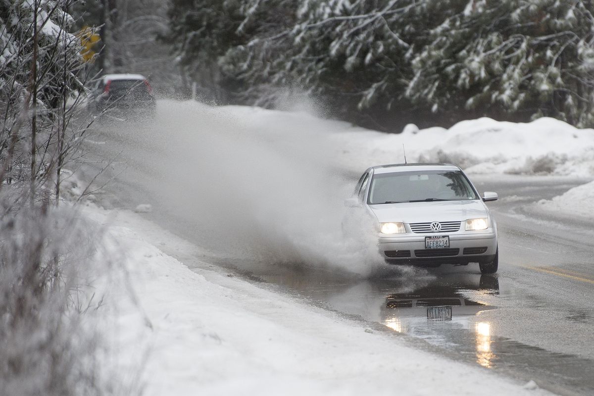 A car swerves to dodge a large puddle of melting snow during the morning commute on Thursday, Feb. 9, 2017, on West Waikiki Road in Spokane, Wash. A weak-forming la Nina in the tropical Pacific Ocean may precede another cold, snowy winter for the city. (Tyler Tjomsland / The Spokesman-Review)