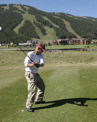 
Steve Steine of Iowa City, Iowa, tees off at the Copper Mountain Golf Club at Copper Mountain, Colo. Ski trails can be seen in the distance.
 (Associated Press / The Spokesman-Review)