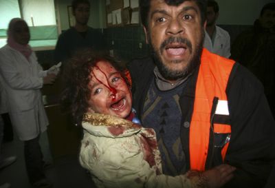 A Palestinian medic carries a wounded girl to the treatment room of Shifa hospital following an Israeli missile strike in Gaza City on Thursday.  (Associated Press / The Spokesman-Review)