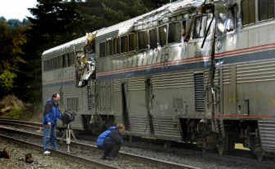 
On Monday, a TV crew from KATU in Portland surveys the damage done to an Amtrak train that derailed Sunday. Workers moved the train to this siding in Stevenson, Wash. 
 (Associated Press / The Spokesman-Review)