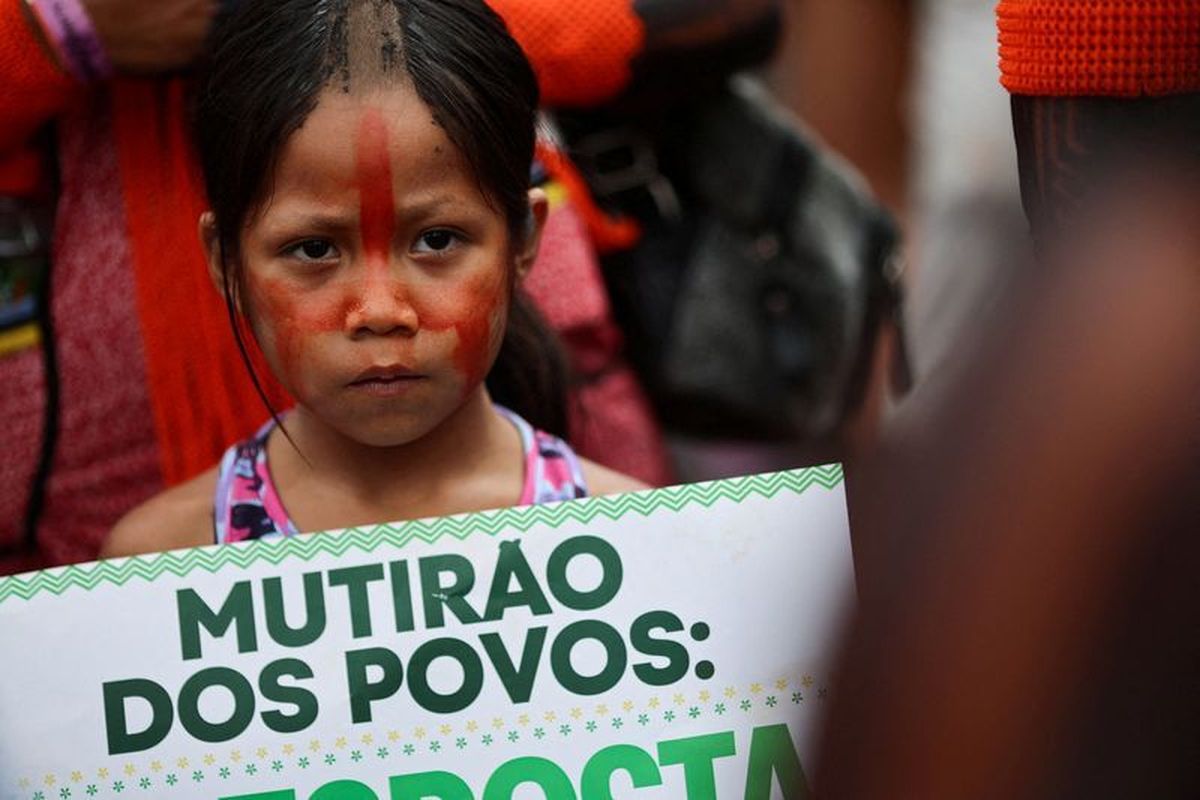 A child holds a sign as people attend a protest to call for climate justice and territorial protection during the U.N. Climate Change Conference (COP30), in Belem, Brazil, November 15, 2025. REUTERS/Adriano Machado  (Adriano Machado)