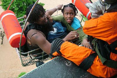 
A woman and her daughter are rescued by a helicopter from a flooded area near Kingston, Jamaica, on Tuesday. Heavy rain from Hurricane Wilma was to blame.
 (Associated Press / The Spokesman-Review)