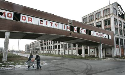 Pedestrians walk past the abandoned Packard plant in east Detroit on Dec. 11. The plant, designed by Albert Kahn, closed in the mid-1950s.  (Associated Press / The Spokesman-Review)