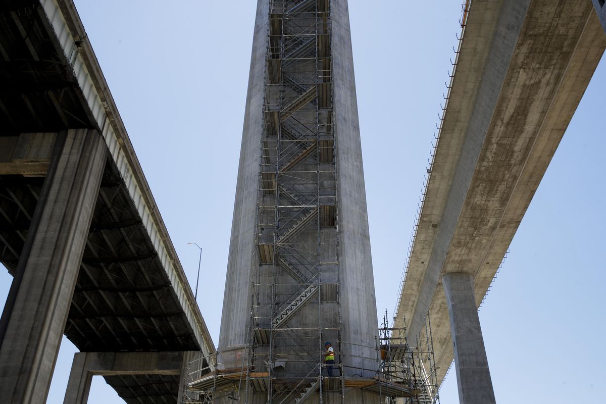 In this July 2, 2018, photo, the old Gerald Desmond Bridge, left, runs parallel to its replacement bridge under construction in Long Beach, Calif. The replacement bridge at the nation’s second-busiest port isn’t just a crucial route for cargo trucks and Southern California commuters – it’s a concrete-and-steel science experiment for engineers and seismologists. (Jae C. Hong / Associated Press)