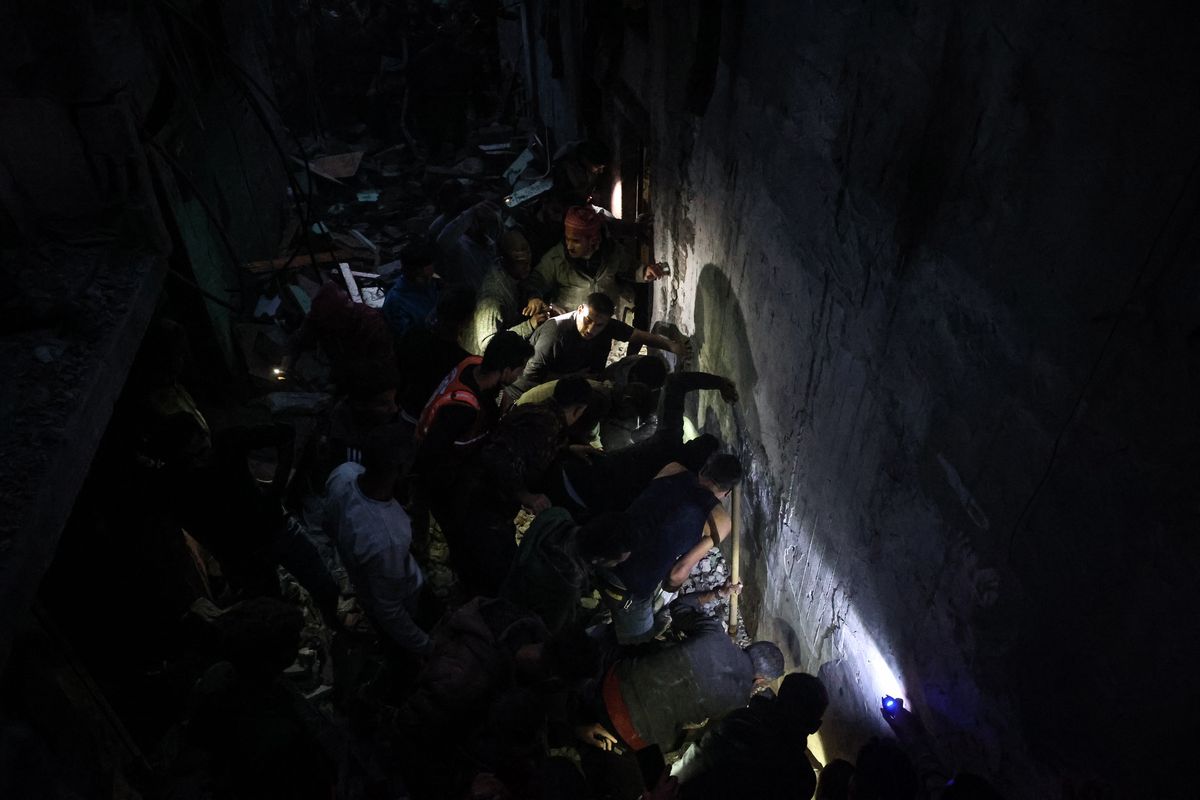 Rescuers try to free people trapped under a building in the Gaza city of Rafah after it was hit by an airstrike early Tuesday. (Loay Ayyoub/For The Washington Post)