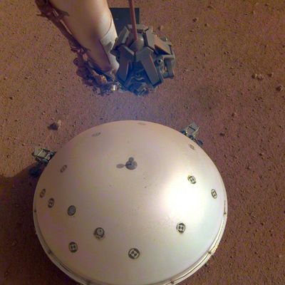 This photo made available by NASA on Tuesday shows the InSight lander’s domed wind and thermal shield, which covers a seismometer, on the 110th Martian day, or sol, of the mission. On Tuesday, the space agency announced the instrument picked up a gentle rumble, believed to be the first marsquake ever detected. (NASA)