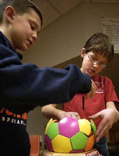 
Audubon Elementary fourth-graders Shane Pethers, 10, left, and Patric  Seaman, 9, put together a Buckyball on Monday. The Pacific Center's Mathfinder van visited the school so students could explore the world of symmetry. 
 (Liz Kishimoto / The Spokesman-Review)