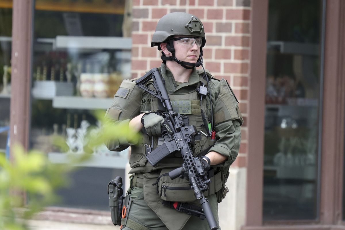 A law enforcement officer watches as people are evacuated from an Anthropologie store in Highland Park on Monday, July 4, 2022, after a shooter fired on the northern suburb