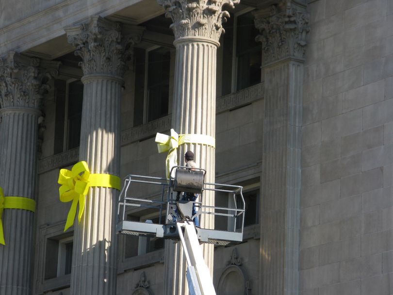 Faded yellow ribbons on the front of Idaho's state Capitol in Boise are replaced on Thursday, thanks to a donation from Support Our Trooops (Betsy Russell)