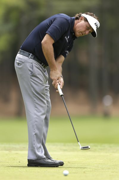 Phil Mickelson watches his putt on the third hole on his way to a 5-under 67 during the second round at Quail Hollow on Friday. (Associated Press)