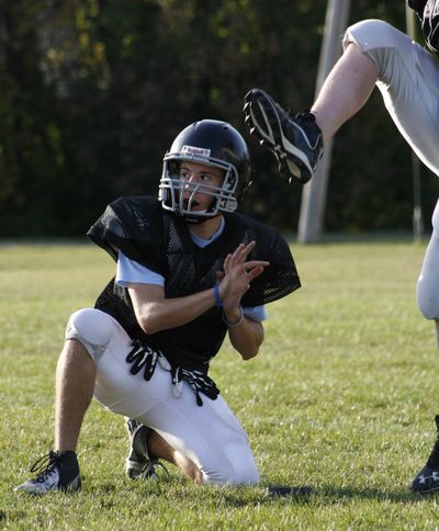 Dylan Henson, 14, watching a kicker’s ball at his local park district football practice in Oak Forest, Ill., plays three sports as does his brother. The sports have become their family’s main focus. (Associated Press)