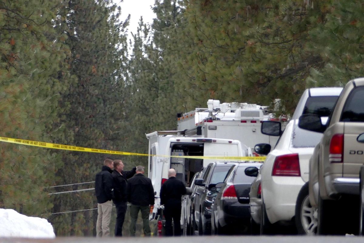 Investigators stand outside a rural home on N. Leslie Lane Tuesday, Mar. 7, 2017, and confer about the domestic situation that led to the exchange of gunfire Monday night after law enforcement was called to the scene. A sheriff