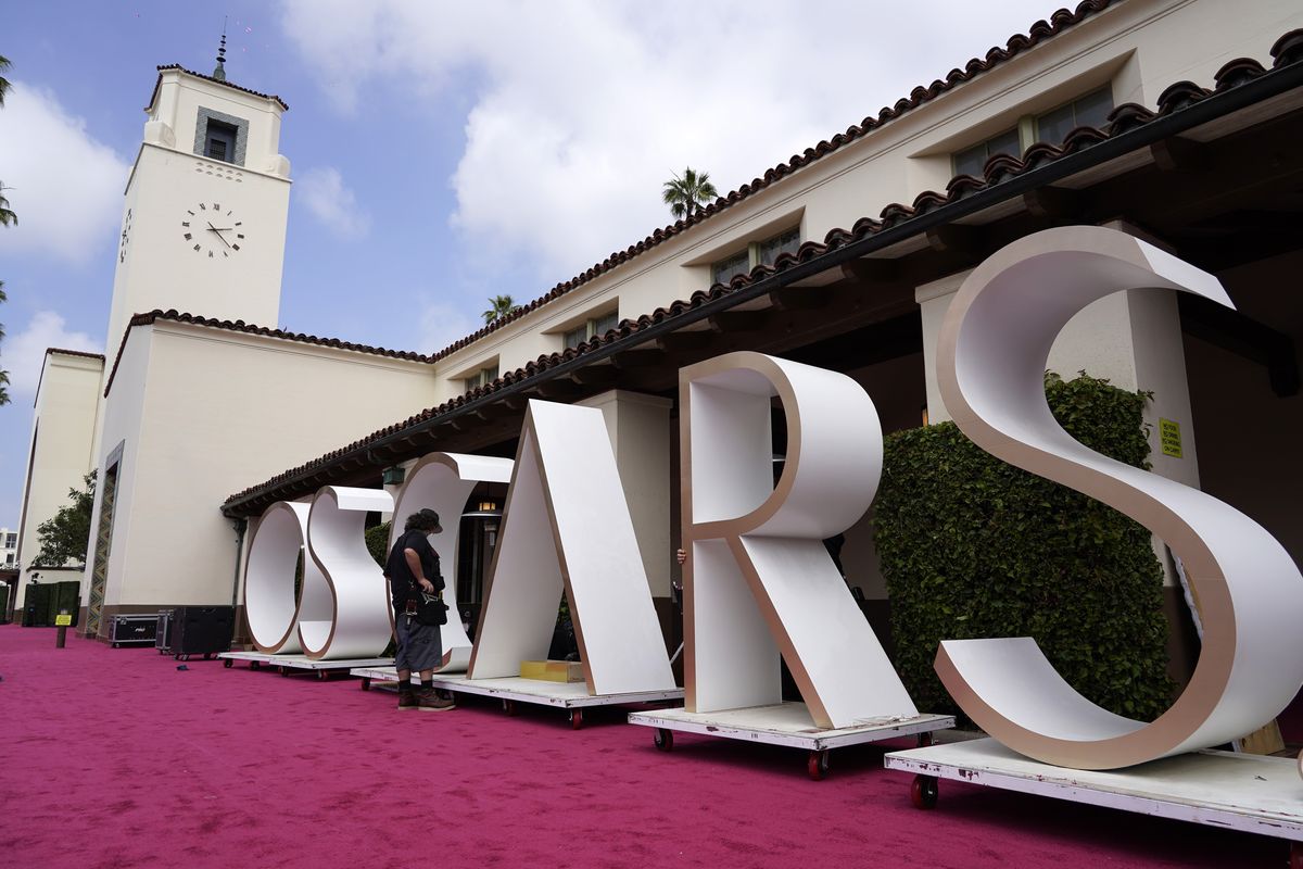 An Academy Awards crew member looks over a background element for the red carpet at Union Station, one of the locations for Sunday