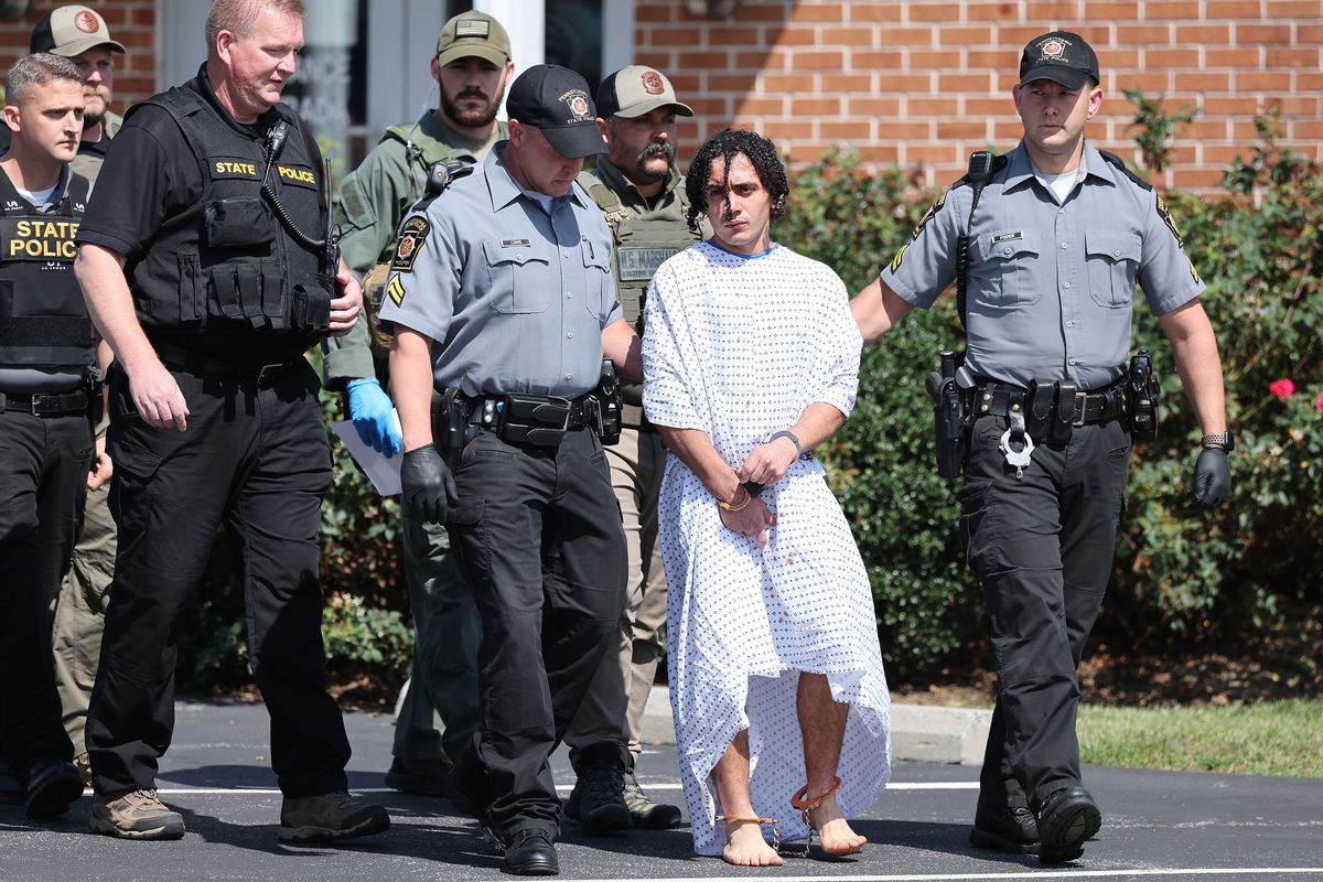 Danelo Cavalcante, center, is escorted from the Pennsylvania State Police barracks in Avondale, Pa., on Wednesday. (David Maialetti)