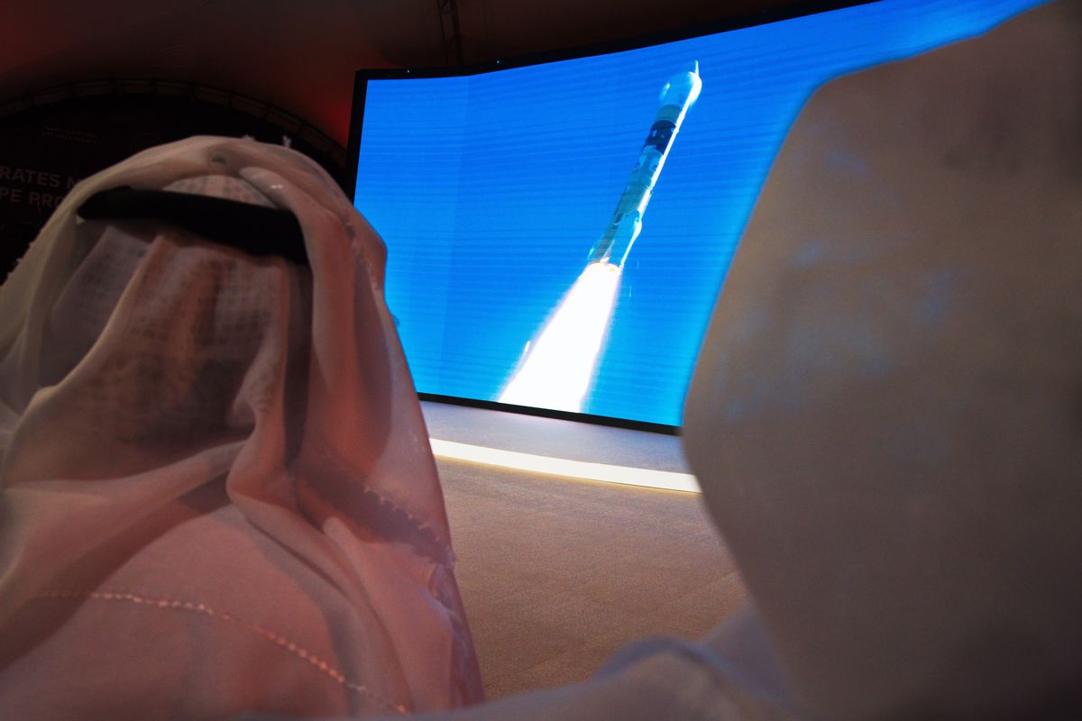 FILE - In this Monday, July 20, 2020 file photo, men watch the launch of the "Amal" or "Hope" space probe at the Mohammed bin Rashid Space Center in Dubai, United Arab Emirates. The orbiter is scheduled to reach Mars on Tuesday, Feb. 9, 2021, followed less than 24 hours later by China’s orbiter-rover combo. NASA’s rover will arrive on the scene a week later, on Feb. 18, to collect rocks for return to Earth _ a key step in determining whether life ever existed at Mars.  (Jon Gambrell)
