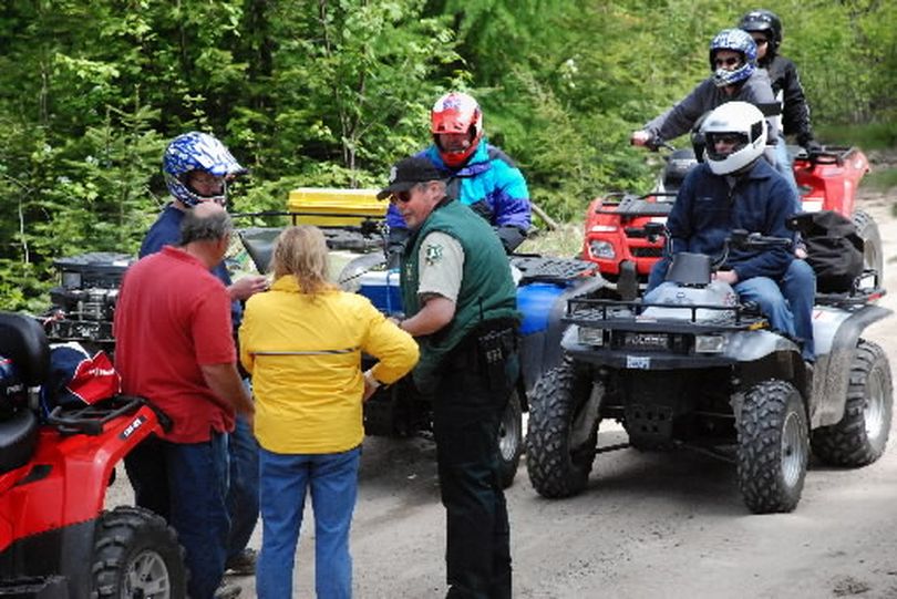 Mike Mumford, Colville National Forest law enforcement officer, talks with a group of ATV riders during his Memorial Day weekend patrol in Pend Oreille County. The riders were on a road that is closed to ATV traffic.  (Rich Landers)