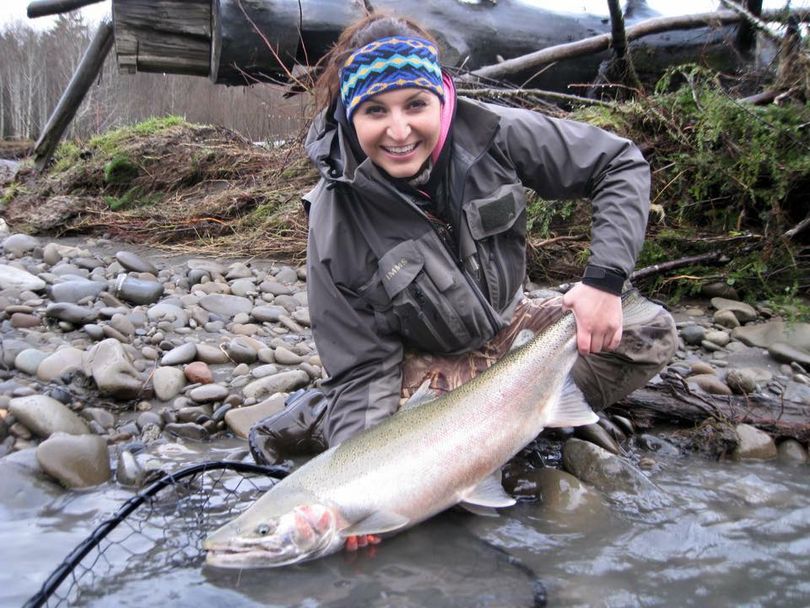 Ashley Lewis, guide and owner of Quinault Sport Angling, lands a steelhead on a Washington Coast stream.  (Pete Hoberg)