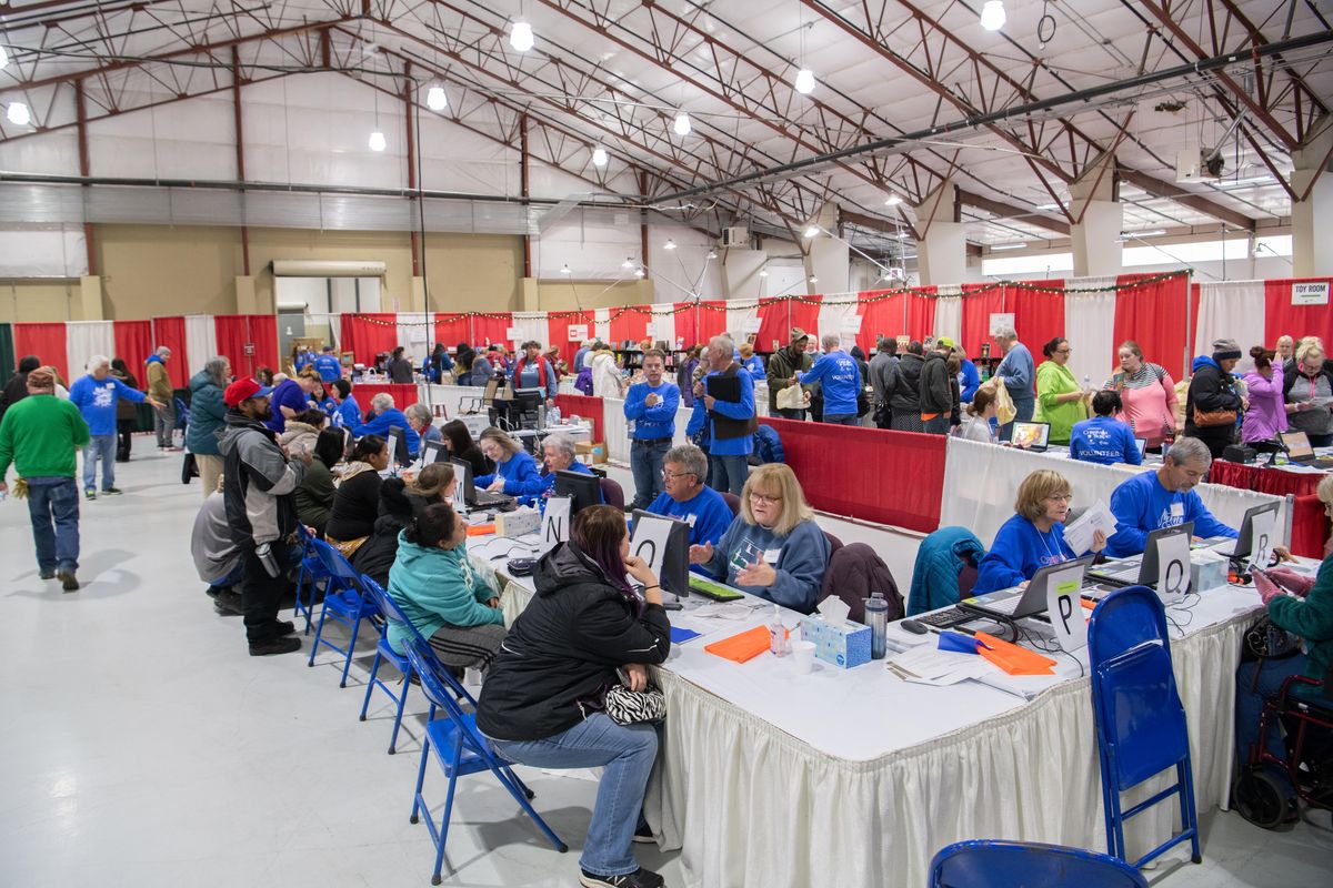In the middle of the agricultural building where the annual charity sets up, dozens of volunteers check parents in and verify names and family size of recipients before the visitors are allowed to choose books and toys for their children at the Christmas Bureau Wednesday, Dec. 11, 2019, the first day of the annual charity, which will be open (except for Sunday) through Friday, Dec. 20.  Jesse Tinsley/THE SPOKESMAN-REVIEW (Jesse Tinsley / The Spokesman-Review)