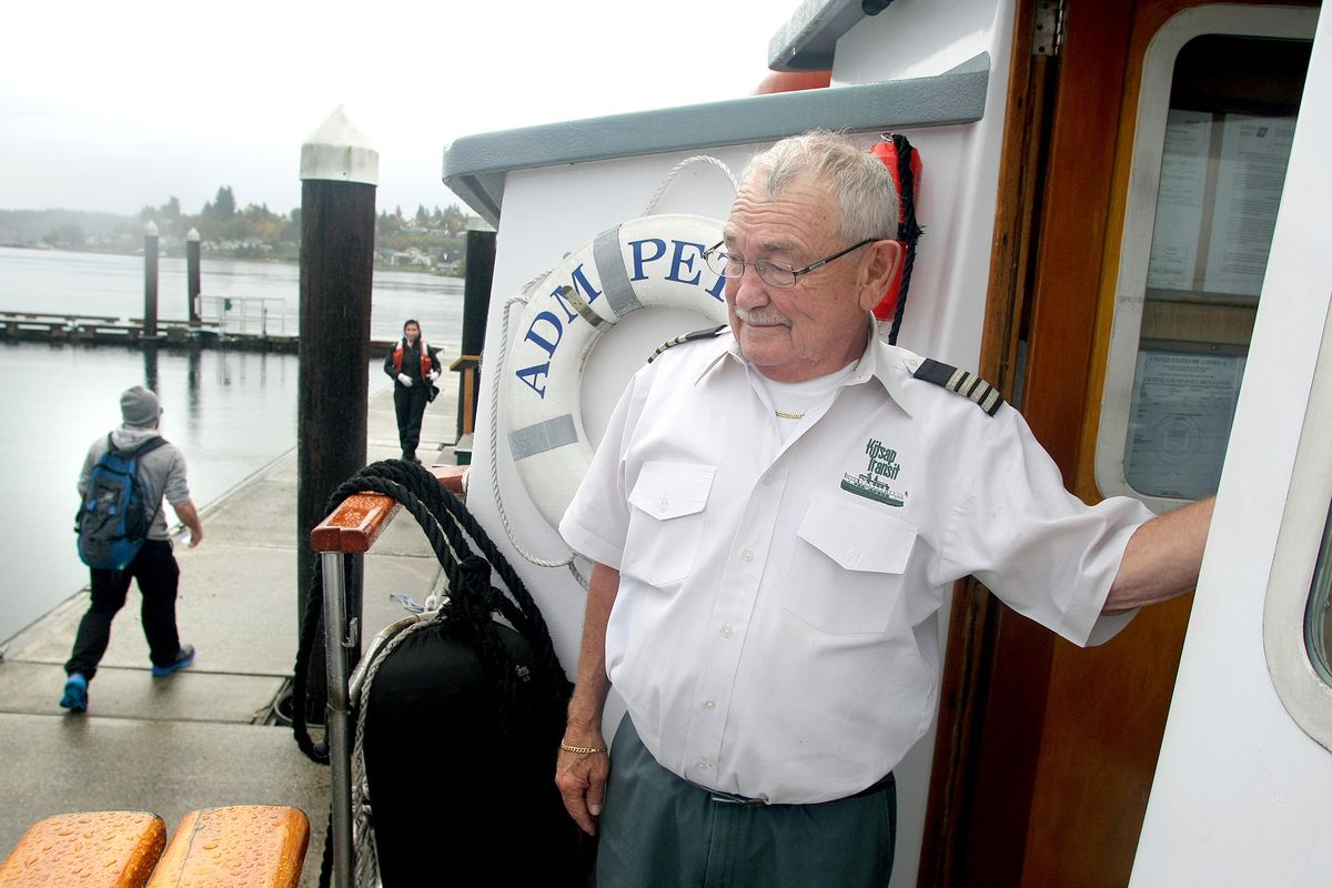 Willis “Bill” Nearhoff, captain of the Admiral Pete passenger ferry, watches as passengers walk on the dock to board the ferry in Port Orchard. (Associated Press)