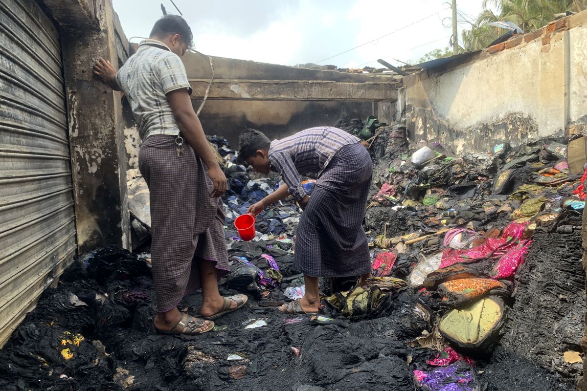 People inspect the debris after a fire in a makeshift market near a Rohingya refugee camp in Kutupalong, Bangladesh, Friday, April 2, 2021. The fire broke out early Friday when residents of the sprawling Kutupalong camp for Myanmar