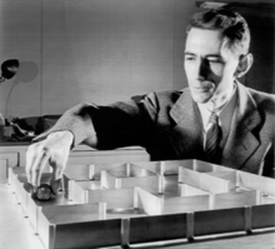 Claude Shannon figured out how to send information through binary code – like our phones do. Here, he’s working with a robot “mouse” he invented with researcher Betty Shannon. It was one of the first experiments with artificial intelligence.  (Bell Labs)