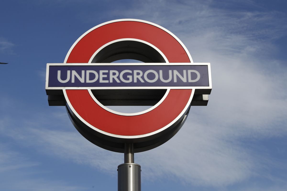 A bird flies above an Underground sign at one of the entrances to King