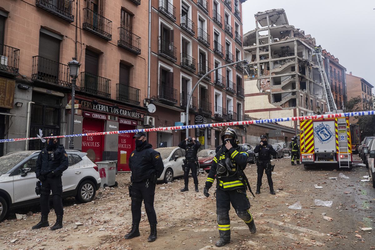 Police officers cordon off Toledo Street following an explosion in downtown Madrid, Spain, Wednesday, Jan. 20, 2021. A loud explosion has partially destroyed a small building flanked by a school and a nursing home in the center of Spain