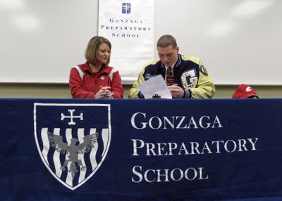 Gonzaga Prep’s Travis Long, a Washington State recruit, signs his letter of intent with his mother Kathleen Cronquist by his side.  (Colin Mulvany / The Spokesman-Review)
