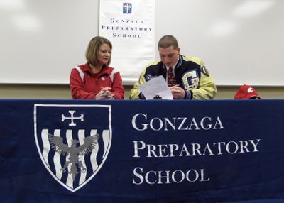 Gonzaga Prep’s Travis Long, a Washington State recruit, signs his letter of intent with his mother Kathleen Cronquist by his side. (Colin Mulvany / The Spokesman-Review)