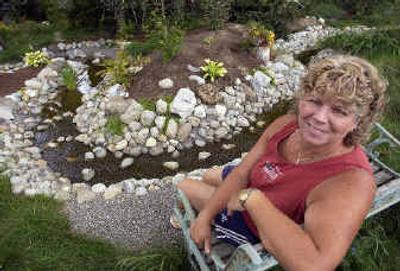 
Lisa Burns sits beside the stream she dug herself. It's one of her favorite garden features. 
 (Liz Kishimoto photos/ / The Spokesman-Review)