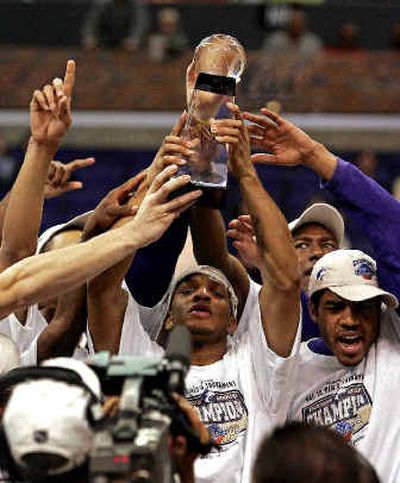 
The University of Washington's Will Conroy, center, hoists the championship trophy after the Huskies claimed their first Pacific-10 Conference tournament title. 
 (Associated Press / The Spokesman-Review)