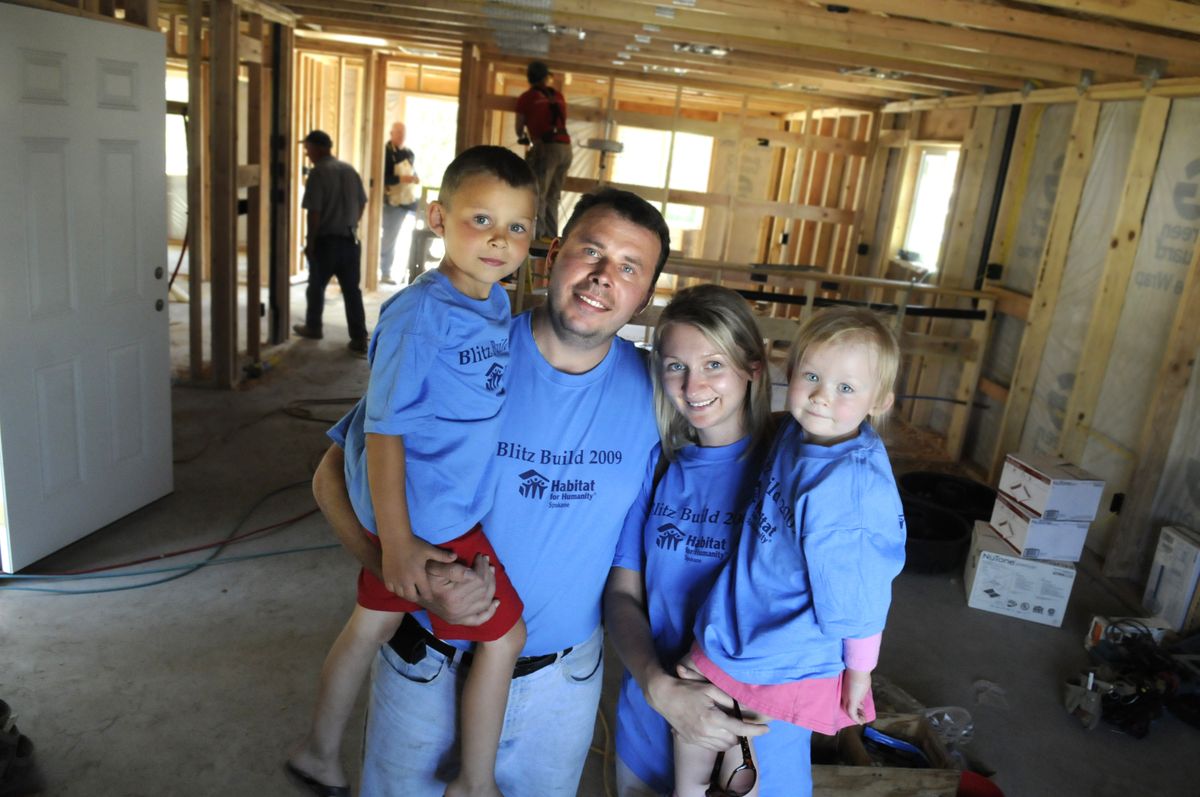 Mikalai and Maryia Belavus, and their two children, Mikalai, left, and Milana stand in the living room of their future house last week.  (Jesse Tinsley / The Spokesman-Review)