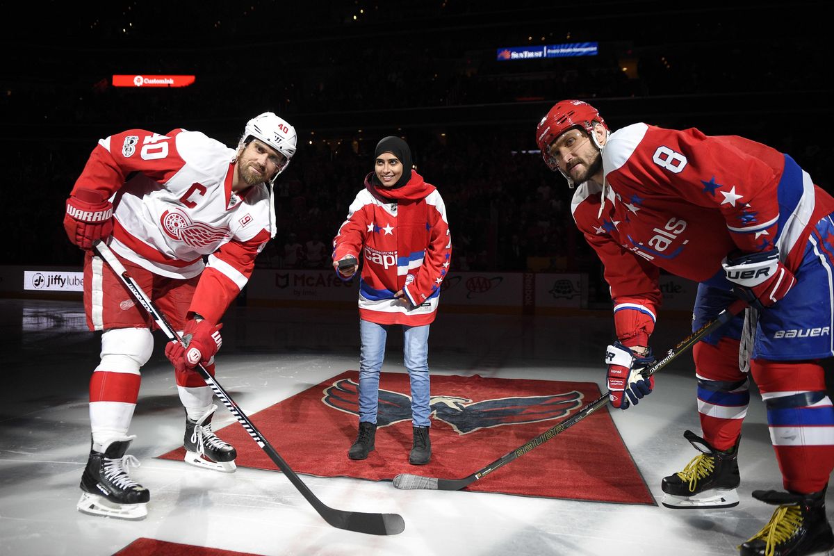 Fatima Al Ali, of the United Arab Emirates, center, takes part in a ceremonial puck drop before an NHL hockey game with Washington Capitals left wing Alex Ovechkin (8), of Russia, and Detroit Red Wings left wing Henrik Zetterberg (40), of Sweden, Thursday, Feb. 9, 2017, in Washington. (Nick Wass / Associated Press)
